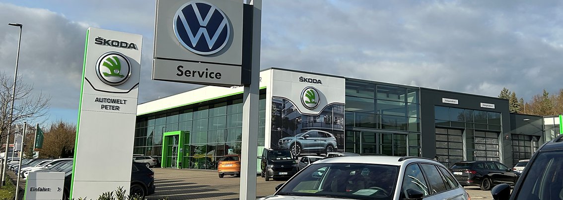 Aussenansicht des Autowelt Peter Autohauses in Nordhausen. Im Vordergrund ein Schild mit Volkswagen-Logo.