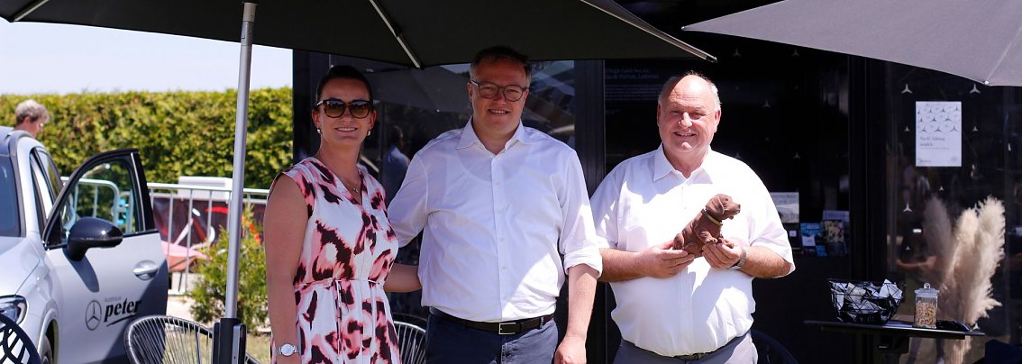 Christina Dost, Mario Voigt und Helmut Peter beim Reitturnier in Immenrode, stehend unter Sonnenschirmen neben einem Mercedes-Benz des Autohaus Peter