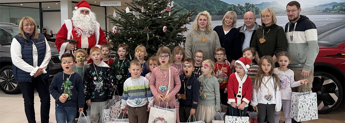 Gruppenbild der Kita-Gruppe vor dem geschmückten Weihnachtsbaum im Skoda Autohaus Nordhausen