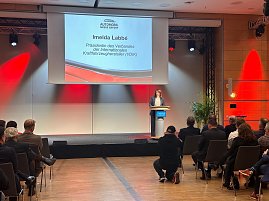 Imelda Labbé, Präsidentin des Verbandes der Internationalen Kraftfahrzeughersteller (VDIK), spricht am Rednerpult. Ihr Name und Titel sind groß auf der Leinwand zu sehen.