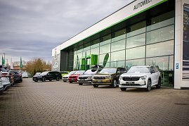 Reihe von neuen �koda-Fahrzeugen vor der Glasfassade des Autohauses. Verschiedene Modelle sind aufgereiht.