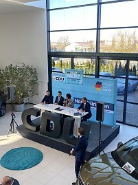 Blick leicht von oben auf Podiumsdiskussion mit vier Teilnehmenden, darunter Colette Boos-John. Vor der B&uuml;hne gro&szlig;e schwarze CDU-Buchstaben, im Hintergrund ein Skoda-Auto.