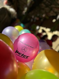 Mehrere bunte Luftballons mit der Aufschrift �Helau, Alaaf & Ahoi!� und dem Autohaus-Peter-Logo, im Vordergrund ein pinkfarbener Ballon im Fokus.