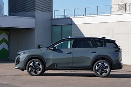 Linke Seitenansicht des grauen Citroën C5 Aircross, geparkt vor einem modernen Gebäude.