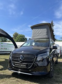 Mercedes-Benz Van mit Aufstelldach: Schwarzer Mercedes-Benz Van mit ge&ouml;ffnetem Aufstelldach auf der Messefl&auml;che.