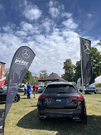 R&uuml;ckansicht SUV mit Fahnen: Schwarzer Mercedes-Benz SUV von hinten, flankiert von Fahnen der Autohaus Peter Gruppe und Mercedes-Benz.