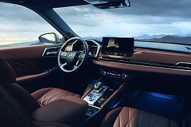 Innenraum mit Armaturenbrett: Moderner Innenraum des Mitsubishi Outlander mit braunen Ledersitzen, digitalem Display, großem Touchscreen in der Mitte und Blick auf eine Berglandschaft durch die Frontscheibe.