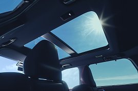 Panoramadach: Blick aus dem Innenraum des Mitsubishi Outlander auf das geöffnete Panoramadach mit Sonnenlicht und blauem Himmel.