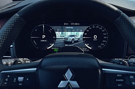 Digitales Cockpit: Nahaufnahme des digitalen Fahrerdisplays des Mitsubishi Outlander mit Geschwindigkeitsanzeige, Energieflussanzeige und Fahrzeugabbildung in der Mitte.