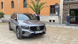 Grauer Mercedes GLB mit Autohaus-Peter-Logo vor dem historischen Achteckhaus Sondershausen, zwei Gäste unterhalten sich am Fahrzeug.