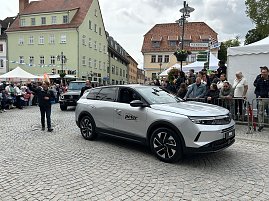 Beim Festumzug in Sondershausen präsentiert das Autohaus Peter einen Opel und einen Mercedes-Benz. Zahlreiche Zuschauer säumen die Straßen der Altstadt.