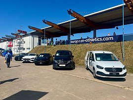 Mehrere Mercedes-Benz Fahrzeuge, präsentiert vom Autohaus Peter, stehen aufgereiht am Rand des Stadions beim Anhalt 2025 Leichtathletik-Meeting. Unter den ausgestellten Autos sind ein weißer eCitan, ein schwarzer EQV und weitere Mercedes-Modelle zu sehen. Im Hintergrund befinden sich Zuschauertribünen, ein Banner mit der Aufschrift ‚european-athletics.com‘ und einige Besucher auf dem Gelände.