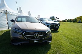 Mehrere Mercedes-Benz Fahrzeuge stehen auf einer gr&uuml;nen Wiese vor wei&szlig;en Eventzelten beim Gro&szlig;en Preis von Immenrode 2025. 