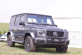 Ein grauer Mercedes-Benz G-Klasse Gel&auml;ndewagen mit der Aufschrift �The G-Klass Electrified� steht auf einer gr&uuml;nen Wiese beim Reitturnier in Immenrode. Im Hintergrund sind ein wei&szlig;es Zelt und Absperrgitter zu sehen.[Mercedes-Benz G 580 mit EQ Technologie | Energieverbrauch kombiniert: 30,3-;27,7 kWh/100 km | CO2-Emissionen kombiniert: 0 g/km | CO2-Klasse: A]