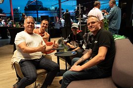 Vier Personen, darunter ein Kind mit Mercedes-Cap, sitzen entspannt in einer Lounge-Ecke. Ein Mann im wei&szlig;en Shirt zeigt beide Daumen hoch.