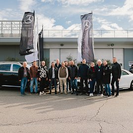 Gruppenfoto der gesammten Teilnehmer vor 2 Maybach Modellen und Mercedes-Benz Fahnen nach der Veranstaltung. [Mercedes-Maybach GLS 600 | Energieverbrauch kombiniert: 14-13,7 l/100 km | CO2;-Emissionen kombiniert: 316-310 g/km | CO2;-Klasse: G] [Mercedes-Maybach SL 680 Monogram Series | Energieverbrauch kombiniert: 13,6 l/100 km | CO2;-Emissionen kombiniert: 309 g/km | CO2;-Klasse: G] 