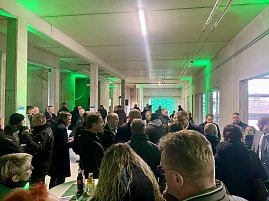 Innenaufnahme des neuen Dekra Gebäudes beim Richtfest mit vielen Gästen, die sich unterhalten.