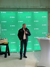 Mario Voigt steht vor grünem Dekra Banner und spricht ins Mikrofon.
