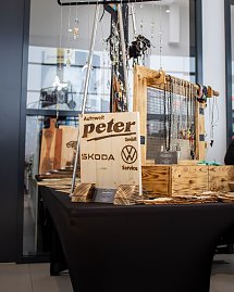 Holzschild Autowelt Peter GmbH mit Skoda- und VW-Logo an einem Schmuck- und Dekostand.