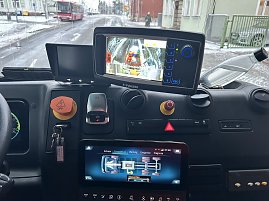Blick in das Cockpit eines M&uuml;llfahrzeugs mit Monitoren und Bedienelementen zur Fahrzeugsteuerung.

