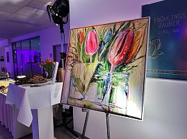 Gem&auml;lde mit Tulpen auf Staffelei neben Buffet im Eventbereich.