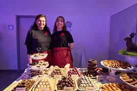 Zwei Servicekr&auml;fte hinter Dessertbuffet mit Pralinen und Geb&auml;ck.