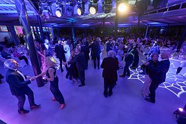 Die Tanzfl&auml;che ist er&ouml;ffnet: Zahlreiche G&auml;ste tanzen in eleganter Abendgarderobe unter stimmungsvoller blauer Beleuchtung.
