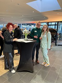 Eine Mitarbeiterin mit zwei Kunden am Check-In.