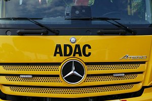 Frontansicht eines gelben Mercedes-Benz Abschleppwagens mit großem schwarzen ADAC-Schriftzug und Mercedes-Stern in der Mitte des Kühlergrills. Rechts das Modellzeichen Atego.