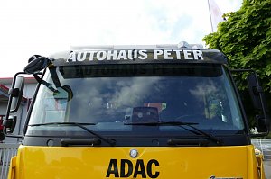 Frontansicht eines gelben ADAC-Abschleppwagens mit der Aufschrift AUTOHAUS PETER über der Windschutzscheibe und dem ADAC-Logo.