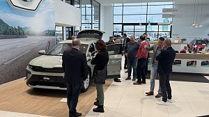 Der neue �koda Elroq steht mit ge&ouml;ffnetem Kofferraum und T&uuml;ren im Ausstellungsraum. Besucher stehen darum herum, einige sehen sich das Interieur an.