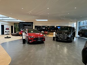Blick in den Kundenwartebereich: Man sieht ein Pkw und ein Van, dahinter Sitzmöglichkeiten sowie Collection-Artikel.