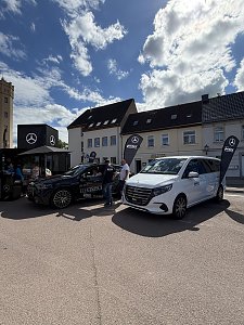 Man sieht unseren Promotion-Stand mit einem schwarzen GLC und einer wei&szlig;en V-Klasse.