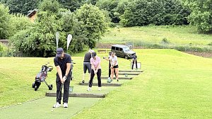 Golferinnen und Golfer trainieren ihre Schl&auml;ge auf der Driving Range des Golfplatzes.