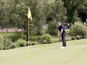 Golfer konzentriert sich auf einen Putt nahe der Fahne auf einem gepflegten Gr&uuml;n.