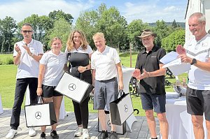 Gewinnerteam pr&auml;sentiert Geschenktaschen bei der Preisverleihung auf der Clubhausterrasse.