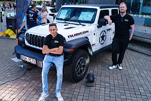 Zwei Mitarbeiter der Autohaus Peter Gruppe pr&auml;sentieren einen wei&szlig;en Jeep Wrangler Rubicon beim Erfurter Nachtlauf 2026