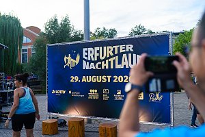 Veranstaltungsfl&auml;che des Erfurter Nachtlaufs 2026 mit gro&szlig;em Veranstaltungsbanner und Siegerpodest.