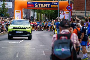 Gr&uuml;ner Jeep Compass der Autohaus Peter Gruppe als F&uuml;hrungsfahrzeug vor dem startenden L&auml;uferfeld beim Erfurter Nachtlauf 2026