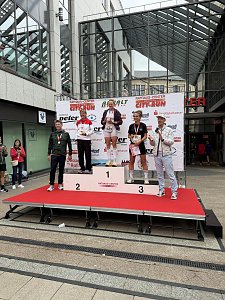 Man sieht eine Siegerehrung der Frauen. Die drei Frauen stehen auf dem Siegertreppchen und halten Pokale oder Urkunden in der Hand. Daneben steht links der Dessauer OB Dr. Robert Reck und rechts daneben steht Ralph Hirsch.