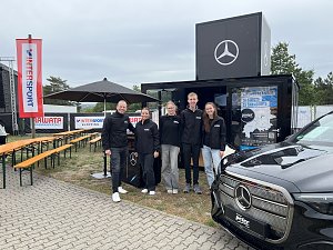 Man sieht das Team vom Autohaus Peter vor dem Promotion-Stand, alle l&auml;cheln in die Kamera.