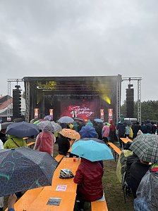 Schlagers&auml;ngerin Sonia Liebing begeistert das Publikum, das unter bunten Regenschirmen feiert.