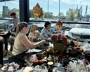 Besucherinnen und Kinder gestalten gemeinsam mit Flower Power herbstliche Kr&auml;nze aus Blumen und Naturmaterialien beim �koda BEST DAY.