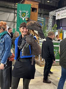 Frau mit einem Falken auf dem Arm in der Messehalle
