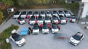 Drohnenaufnahme der Opel-Fahrzeugflotte im Th&uuml;ringer-HC-Design, aufgestellt in mehreren Reihen mit Spielerinnen und Verantwortlichen dazwischen.