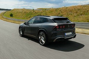 man sieht einen vollelektrischen AMG GT aus dem SUV-Segment. Er f&auml;hrt auf einer Stra&szlig;e und man erkennt die Hinterseite des Fahrzeugs. 