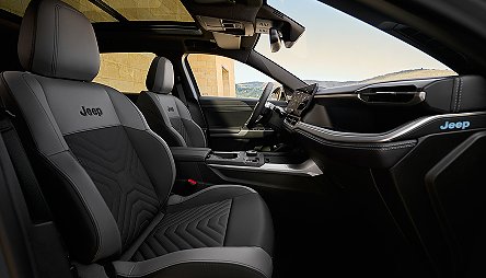 Der neue Jeep&reg; Compass e-Hybrid - Innenraum des Jeep Compass mit schwarzen Sitzen, modernem Cockpit und gro&szlig;em Panoramadach, Sicht nach drau&szlig;en.